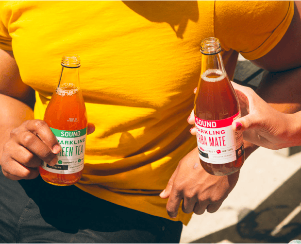 Women influencer posing with juice bottles