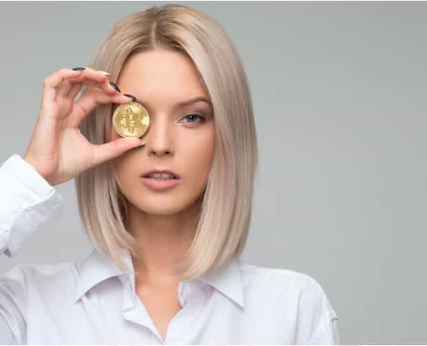 A girl posing with gold coin, placed in front of her eye